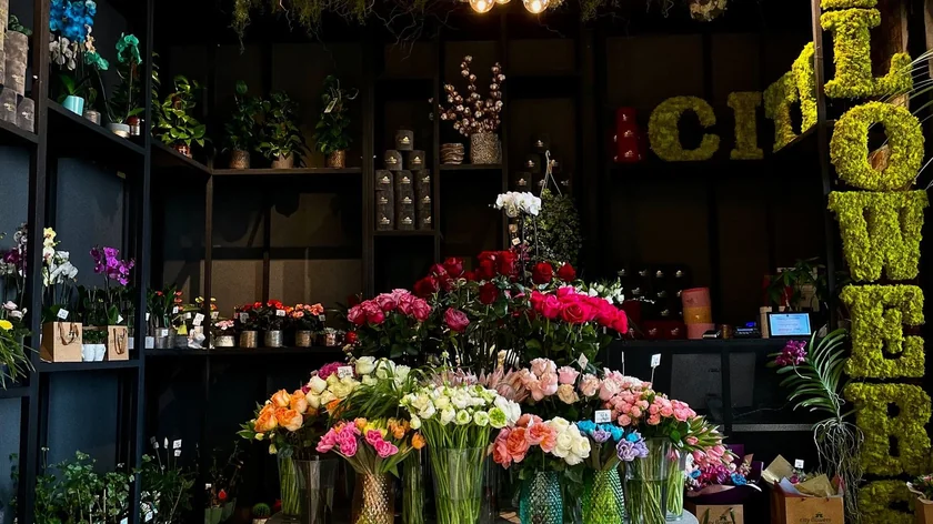 Intérieur d’une boutique de fleurs, avec des bouquets colorés et des plantes en rayon.
