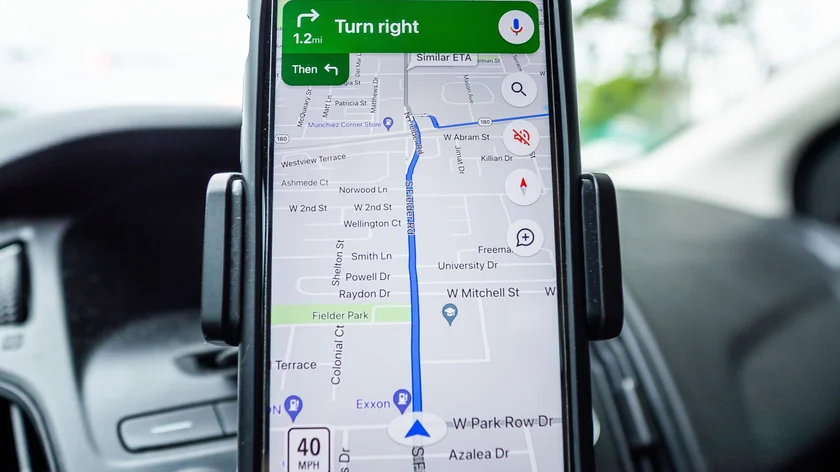 Un téléphone fixé sur un tableau de bord affiche une carte de navigation GPS.