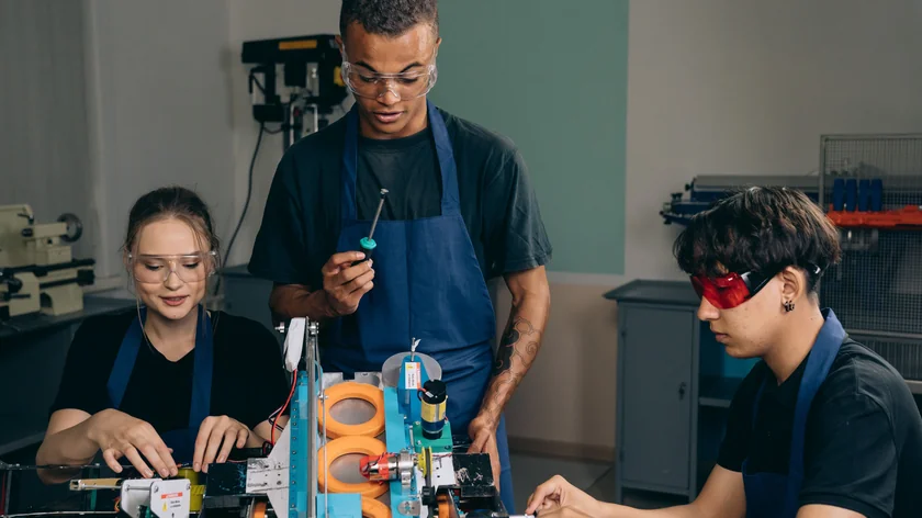 Plusieurs personnes travaillent ensemble dans un atelier équipé d’outils et d’ordinateurs.
