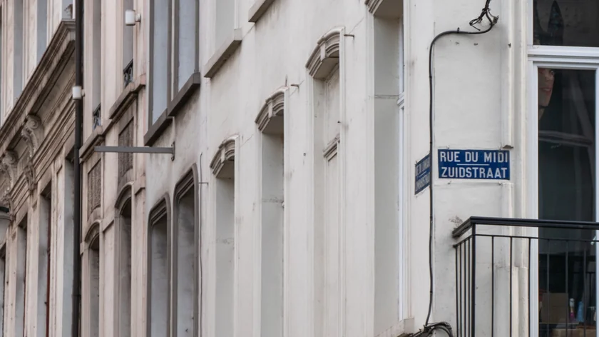 Une plaque de rue bilingue apparaît sur la façade d’un bâtiment à Bruxelles.