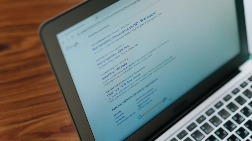 Un ordinateur portable photographié de biais affiche une page de résultats de recherche Google.